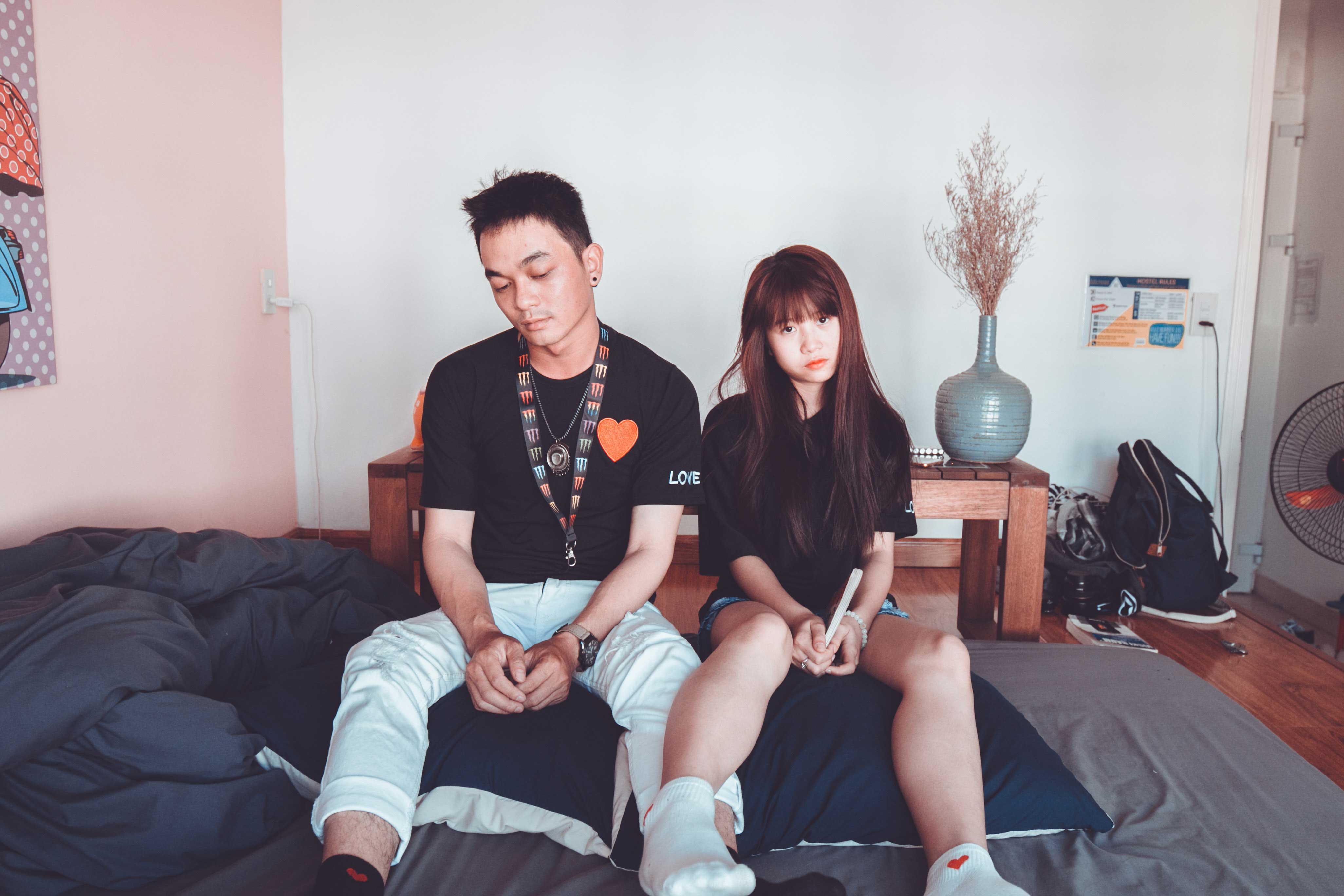 Asian couple sat on bed
